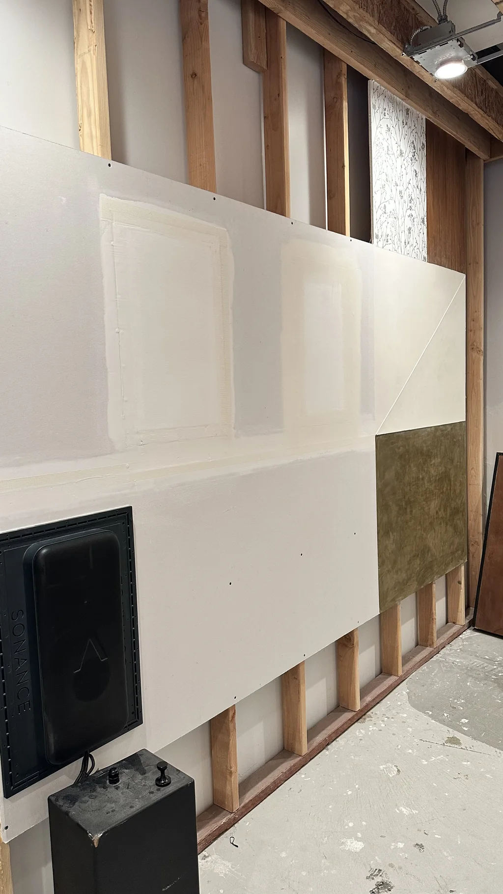 Invisible speaker wall showing successive plaster skim stages
